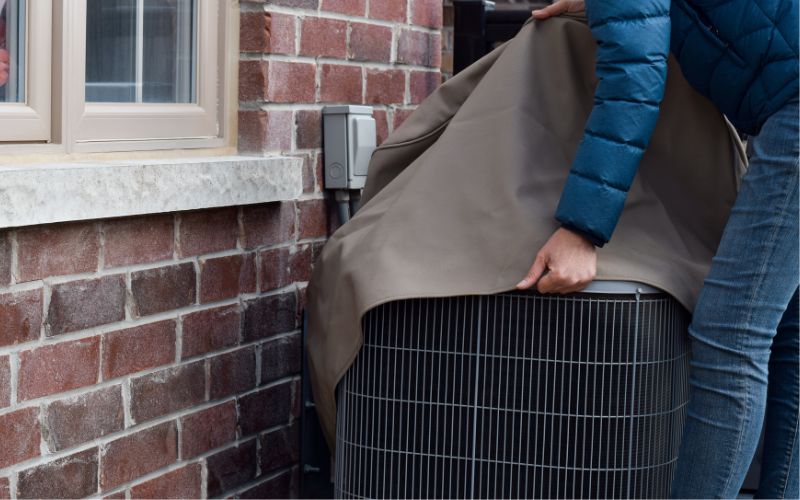 AC unit being covered for the winter - How to Prepare Your Home's Heating and Cooling System for Winter